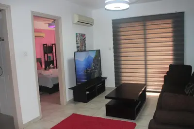 a living room with a couch and a flat screen tv at Marina Court Holiday Flat in Larnaka
