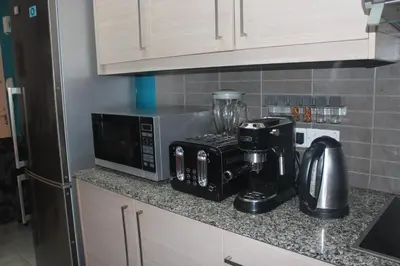 a kitchen counter with a coffee maker and a microwave at Marina Court Holiday Flat in Larnaka