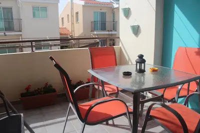 a table and chairs sitting on a balcony at Marina Court Holiday Flat in Larnaka
