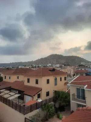 a city with houses and a mountain in the background at Marina Court Holiday Flat in Larnaka