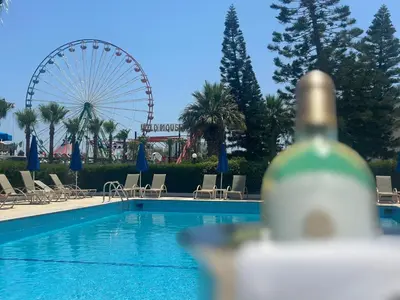 a swimming pool with a ferris wheel in the background at Napa Jay Hotel in Ayia Napa