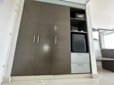 a large wooden cabinet with a tv in a room at Napa Jay Hotel in Ayia Napa