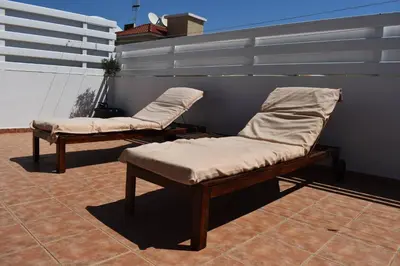 two chaise lounges with pillows on a patio at Sunny Rooftop in Ayia Napa 91Sqm Terrace Delight! in Ayia Napa