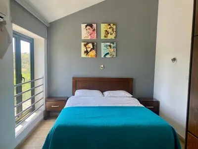 a bedroom with a bed with a blue blanket at Mediterranean View Villa in Protaras