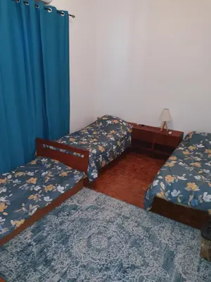a room with two beds and a blue curtain at Indie7house in Pano Lefkara