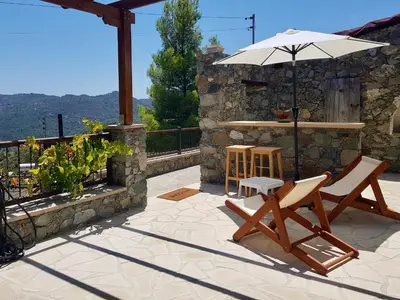 a patio with two chairs and an umbrella at Traditional House with Mountain View - Dierona Village in Dierona