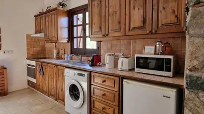 a kitchen with a washing machine and a microwave at Traditional House with Mountain View - Dierona Village in Dierona