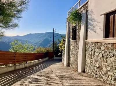 a stone walkway leading to a building with a fence at Traditional House with Mountain View - Dierona Village in Dierona