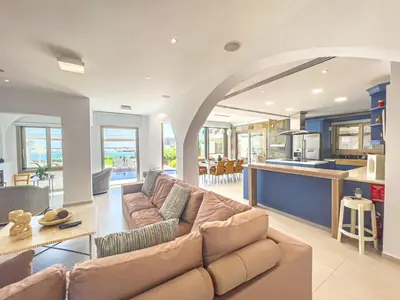 a large living room with a couch and a kitchen at Erato Seafront Luxury Villa in Protaras