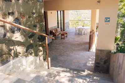 a room with a stone wall and stairs with a table at Stella's Country House in Prodromos