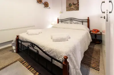 a bedroom with a large bed with white sheets at Stella's Country House in Prodromos
