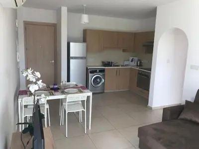 a kitchen with a table and chairs and a kitchen with a stove at Oceania Bay Penthouse in Pyla