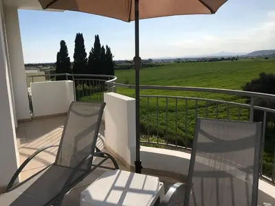 a balcony with two chairs and an umbrella at Oceania Bay Penthouse in Pyla