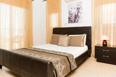 a bedroom with a large bed with a black headboard at VILLA ICARUS IN THE HEART OF PROTARAS in Protaras