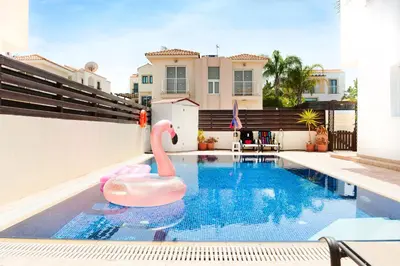 a swimming pool with a pink swan in the water at VILLA ICARUS IN THE HEART OF PROTARAS in Protaras