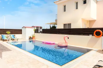 a swimming pool with a pink flamingo in a backyard at VILLA ICARUS IN THE HEART OF PROTARAS in Protaras