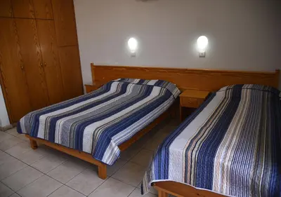 two beds in a hotel room with at Elysso Apartments in Larnaka