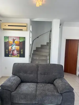 a couch in a living room with a staircase at Chara Cynthiana Villa in Paralimni