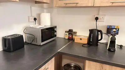 a kitchen counter with a microwave and a television at Unique City Hostel 100 meters from Beach in Larnaka