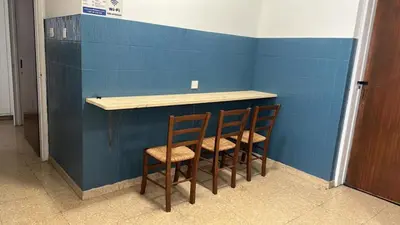 two chairs sitting at a counter with a blue wall at Unique City Hostel 100 meters from Beach in Larnaka