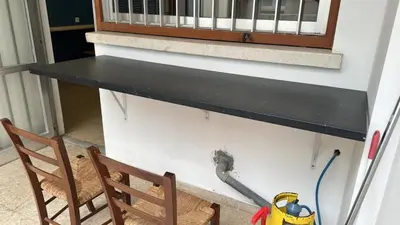 a black counter on a wall next to a chair at Unique City Hostel 100 meters from Beach in Larnaka