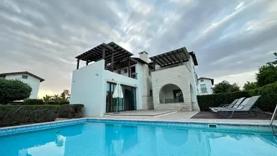 a villa with a swimming pool in front of a house at Merab Holidays Villas - K13 in Ayia Napa