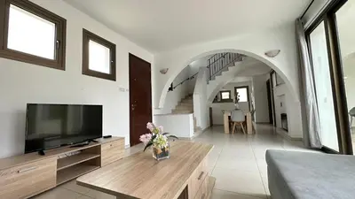 a living room with a flat screen tv and a couch at Merab Holidays Villas - K13 in Ayia Napa