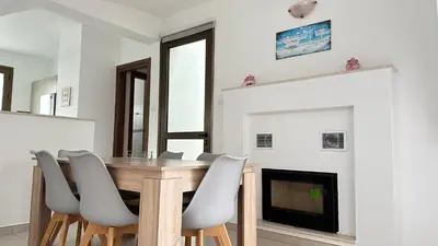 a dining room with a table and chairs and a fireplace at Merab Holidays Villas - K13 in Ayia Napa