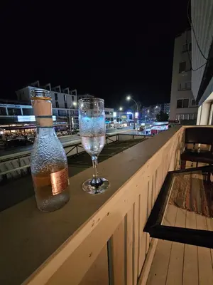 a bottle and a wine glass sitting on a ledge at Touristarea Sea&City Lifestyle studio in Limassol