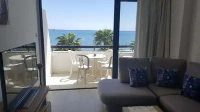 a living room with a couch and a view of the ocean at Sunorama Beach Apartment in Larnaka