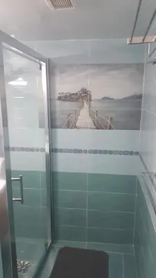 a bathroom with a shower with a painting of a bridge at Sunorama Beach Apartment in Larnaka