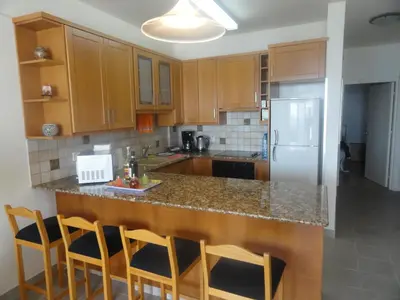 a kitchen with wooden cabinets and a counter top at Sunorama Beach Apartment in Larnaka