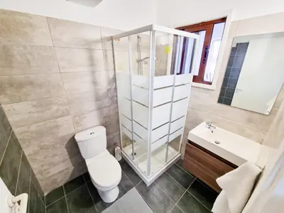 a bathroom with a toilet and a shower and a sink at Home Sweet Home Apartment in Larnaka