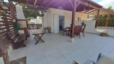 a patio with wooden benches and a table at Comfortable 2BR Seaside House & Free Parking in Larnaka
