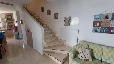 a staircase in a living room with a couch at Comfortable 2BR Seaside House & Free Parking in Larnaka