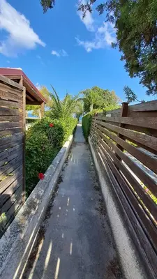 a wooden fence next to a sidewalk next to a fence at Comfortable 2BR Seaside House & Free Parking in Larnaka