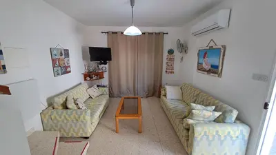 a living room with two couches and a table at Comfortable 2BR Seaside House & Free Parking in Larnaka