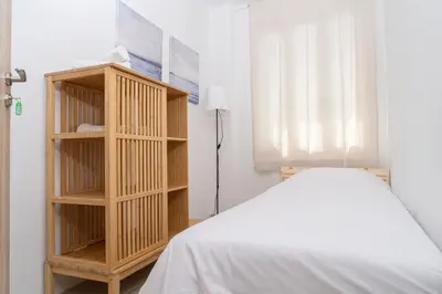 a bedroom with a bed and a book shelf at Private room in shared flat in Nicosia