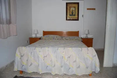 a bed in a bedroom with two night stands and two lamps at Zena Holiday Villa in Pissouri