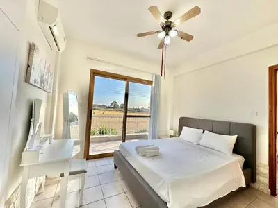 a bedroom with a bed and a large window at Lovely Pool Villa in Pyla in Pyla