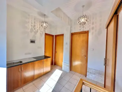 a kitchen with wooden cabinets and two chandeliers at Lovely Pool Villa in Pyla in Pyla