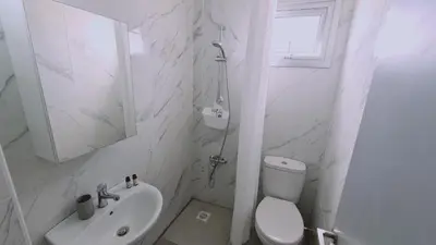 a white bathroom with a toilet and a sink at STAY Napa Living Studios in Ayia Napa