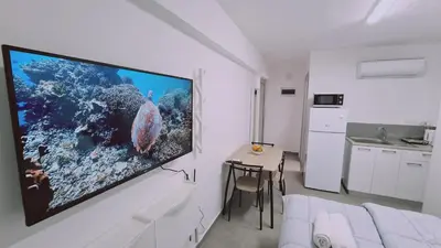 a living room with a large flat screen tv on a wall at STAY Napa Living Studios in Ayia Napa