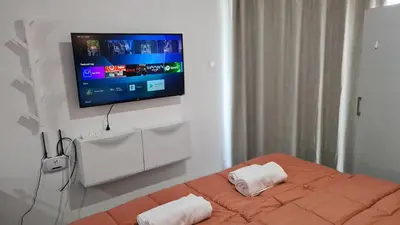 a bedroom with a bed with a tv on the wall at STAY Napa Living Studios in Ayia Napa