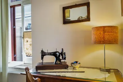 a sewing machine sitting on a glass table with a lamp at Theodorou Stone House in Pano Lefkara