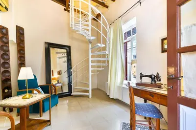 a room with a spiral staircase and a table and chairs at Theodorou Stone House in Pano Lefkara