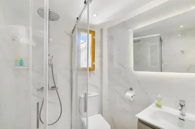 a white bathroom with a shower and a sink at Theodorou Stone House in Pano Lefkara
