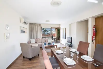a living room with a table and chairs and a couch at Ayia Napa Holiday Apartment Na101 in Ayia Napa