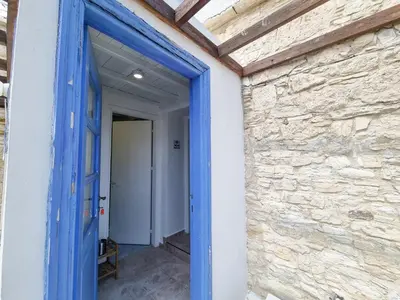 a blue door into a room with a stone wall at Athena's Pool Oasis in Skarinou