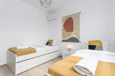 two beds in a room with white walls at Mirage 2-BR Apartment in Larnaca in Larnaka